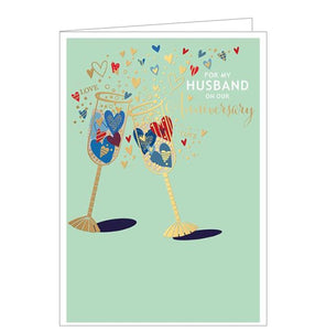 This anniversary card for a special husband is decorated with two golden champagne flutes, filled with blue and gold hearts. The text on the front of the card reads "For my Husband on our Anniversary".