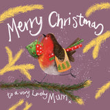 Part of Alex Clark's Christmas card collection, this Christmas card is decorated with Alex's painting of a rosy-cheeked, red-breasted robin marching along a fir-tree branch carrying rolls of wrapping paper and Christmas shopping bags. The text on the front of the card reads "Merry Christmas to a very lovely Mum x".