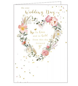 This lovely wedding day card is decorated with a heart-shaped wreath of pink and white flowers. Golden confetti flutters across the card, while text in the centre of the wreath reads "On your Wedding Day...to have and to hold from this day forward".