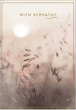 This sympathy card is decorated with a sepia-toned photograph of a meadow scene. Gold text on the card reads "With sympathy".