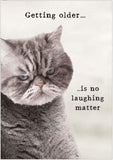 This funny birthday card features a photograph of a grumpy looking grey cat. The caption on the front of the card reads "Getting older..is no laughing matter".