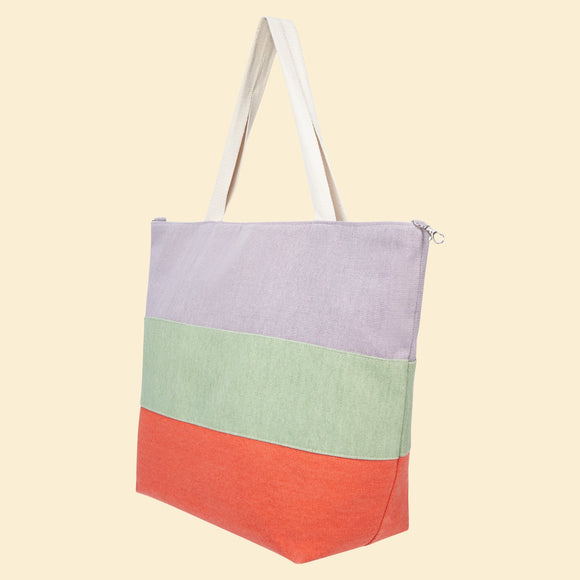 This multi-toned beach bag from fashion brand Powder has three stripes of lilac, sage green and tangerine with neutral straps. With plenty of room inside for snacks, beach towels and holiday reading, this bag perfect for long days at the beach.