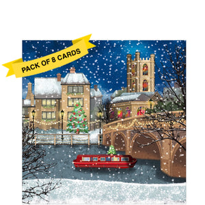 This pack of charity Christmas cards contains 8 cards of one design. The front of the card are decorated a snowy scene of a little red narrowboat, with a Christmas tree on the roof, about to pass beneath a bridge strung with fairy lights.