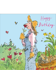 This birthday card is decorated with a Quentin Blake illustration of a woman, dressed in dungarees, a hat and gardening gloves, stopping to smell a flower.