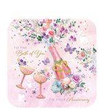 Send your special friends a heartfelt message with this lovely anniversary card. This beautiful anniversary card is decorated with a decoupage'd bottle of champagne alongside two glasses, and floral bouquets on a pink background. The caption on the front of the card reads "To The Both Of You on your Anniversary."