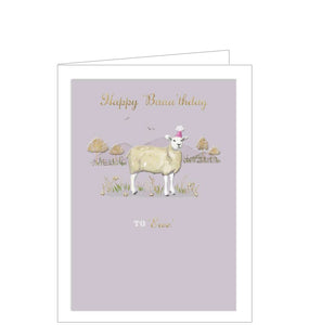 This cute birthday card is decorated with an illustration of a sheep - wearing a pink party hat - standing in a field of golden trees and grass. Gold text on the front of the card reads "Happy Baaa’thday...to 'Ewe'"