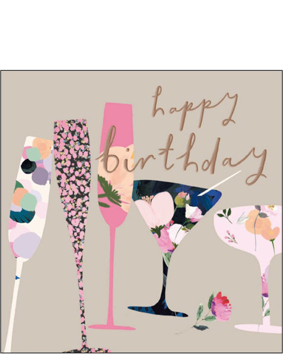 This birthday card from Woodmansterne's collaboration with designer Stephanie Dyment is decorated with patterned champagne and cocktail glasses. Rose gold text on the front of the card reads 