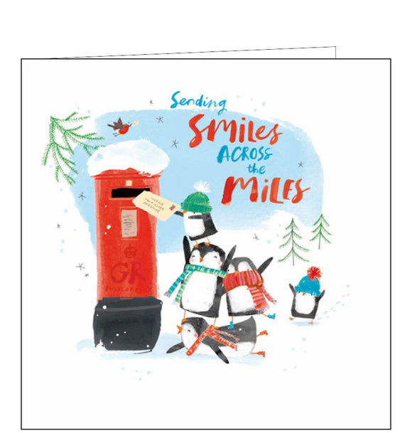 This lovely across the miles christmas card is decorated with a cute illustration of a flock of penguins - in woolly hats and scarves - posting Christmas cards in a red letterbox. The caption on the front of the card reads 