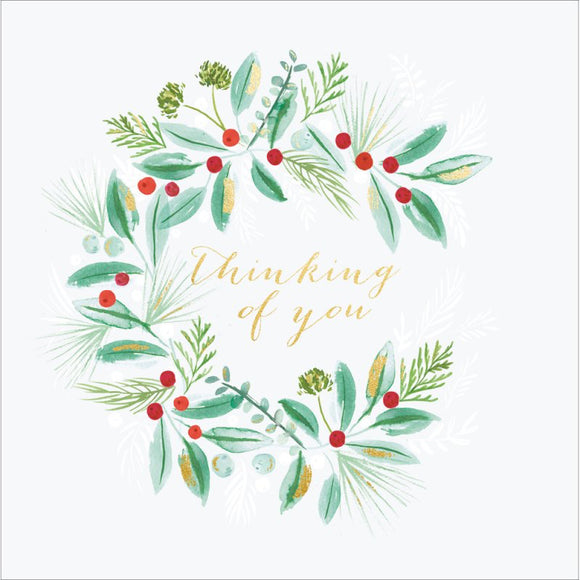 This lovely Christmas card for is decorated with a wreath of green foliage and red berries surrounding gold text that reads 