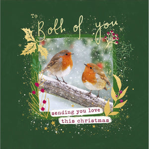 This Christmas card features a photograph of two robins sitting on a snowy branch, framed by a border of gold foliage and red berries. The caption on the front of this Christmas card reads "To both of you...Sending you love this Christmas".