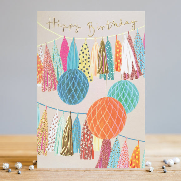 Celebrate birthdays in style with this Louise Tiler birthday card. Decorated with colourful modern tassel bunting and honeycomb paper decorations in shades of pink, blue orange and gold, this card is perfect for  a special birthday. The perfect birthday card to show your loved ones you care!