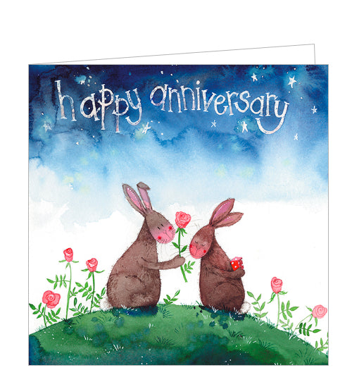 This cute anniversary card from Alex Clark is decorated with a pair of rabbits sitting together on a hillside under an inky night sky. One rabbit holds out a red rose to the other who is holding a wrapped present behind their back. The text on the card reads 