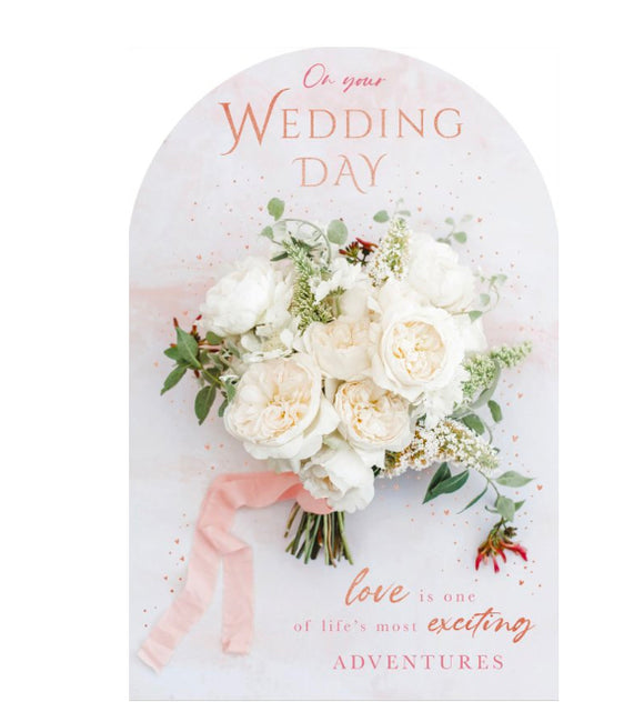 This elegant wedding day card is decorated with the photographic image of a white bouquet with pink ribbon, surrounded by rose gold mini hearts. The top edge is arched.  The pink and gold script on the front of the card reads 