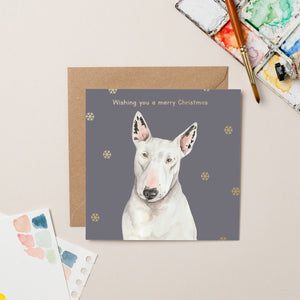 This festive charity Christmas card features Daisy, an English bull terrier who lives on the street with her houseless owner, and has been treated by Street Vet multiple times. The beautiful dusky-blue background and golden snowflakes serve as a backdrop for Daisy, pictured on the front with the caption, "Wishing you a Merry Christmas." The card also includes her heartwarming story on the back.