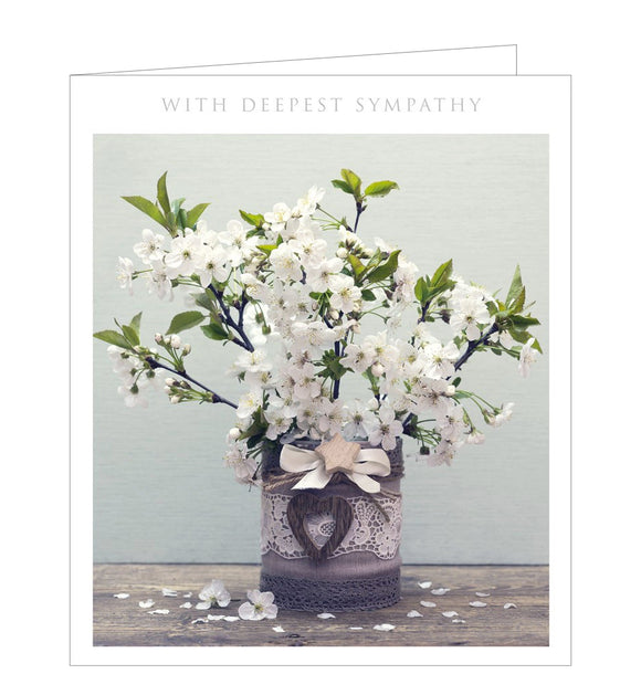 A traditional sympathy card with a photograph of a vase filled with stems of white cherry blossom. The caption on the front of the card reads 