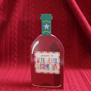 This unusual christmas card is cut into the shape of a bottle of red wine, decorated with a label that reads "have a wine-derful Christmas time".