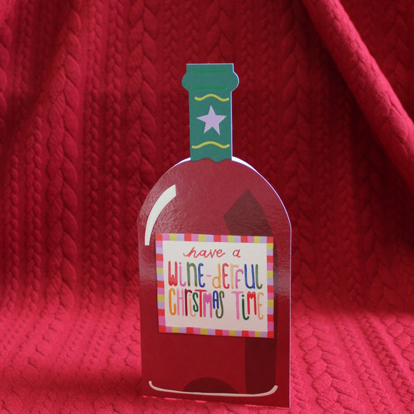This unusual christmas card is cut into the shape of a bottle of red wine, decorated with a label that reads 