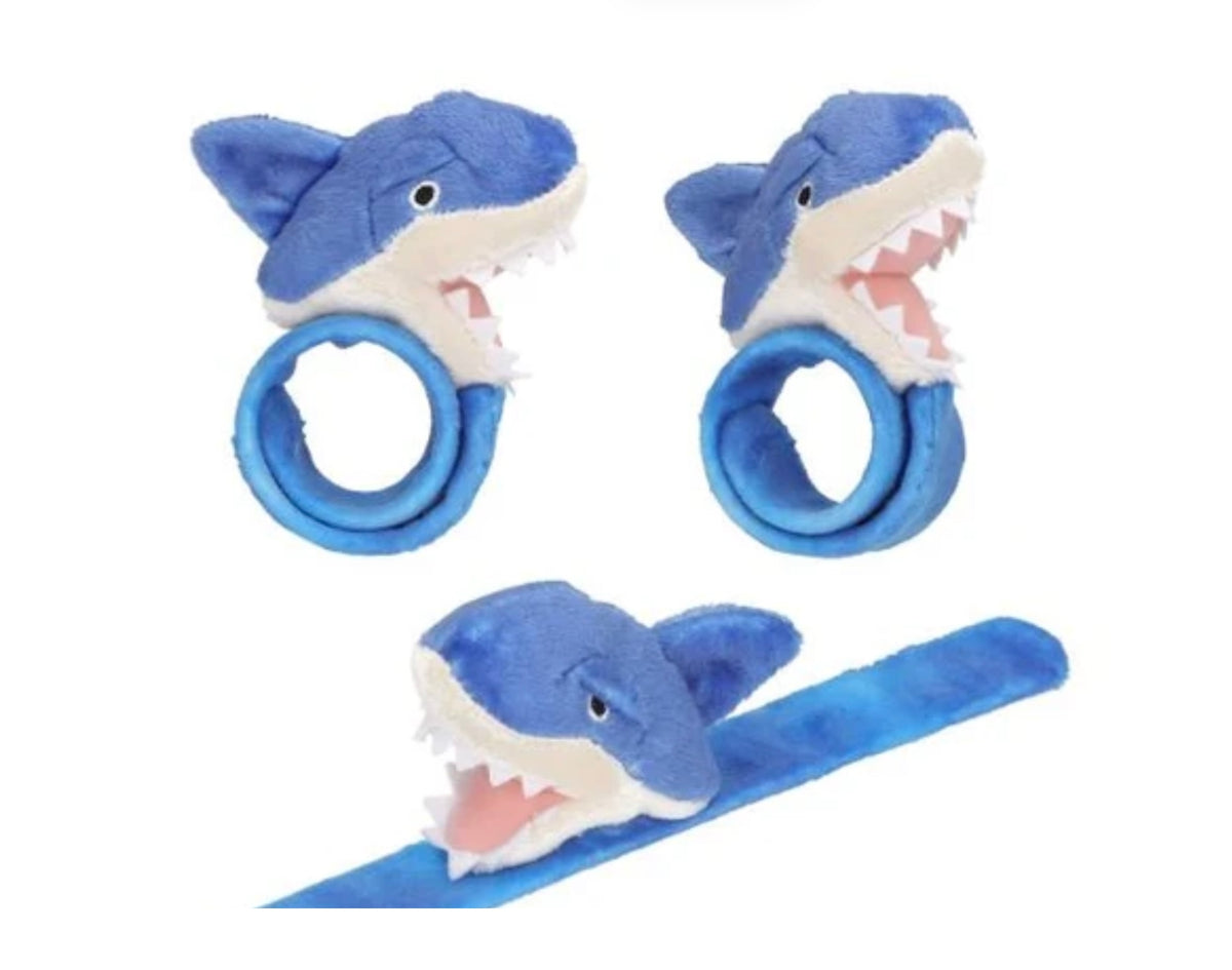 Clip-on wristbands with large plush shark (blue) head. The wristbands, which are completely covered in plush, wrap softly around the arm. From Dino World by Depesche. Material: 100 percent polyester