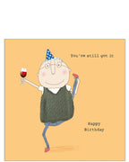 This birthday card features one of Rosie Made a Thing's unmistakably witty and charming illustrations of an elderly man, glass of wine in one hand, going a high kick. The text on the front of the card reads "You've still got it...Happy Birthday".