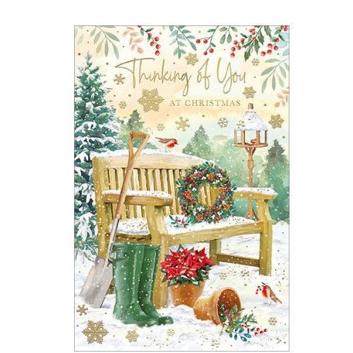 Perfect for letting someone special know they are in your thoughts at a busy time of year, this thinking of you Christmas card is decorated with a scene of a garden bench -  dusted with snow - with a wreath on the seat and a pair of wellington boots beside the bench. The caption on the front of this Christmas card reads 