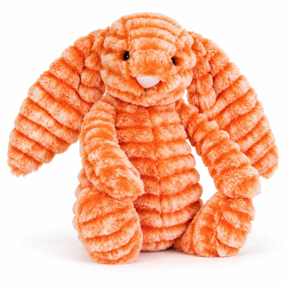 Official Jellycat (jelly cat) independent shop release of a cute and cuddly orange bunny called Fizzleskip for the autumn and winter 2026 season. Image shows a seated Fizzleskip on a white background