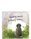 this card shows a dog sitting facing away amongst the daffodils, and holding a daffodil in its mouth. An ideal birthday card from the dog. Text in gold reads "Sending sweet birthday wishes"