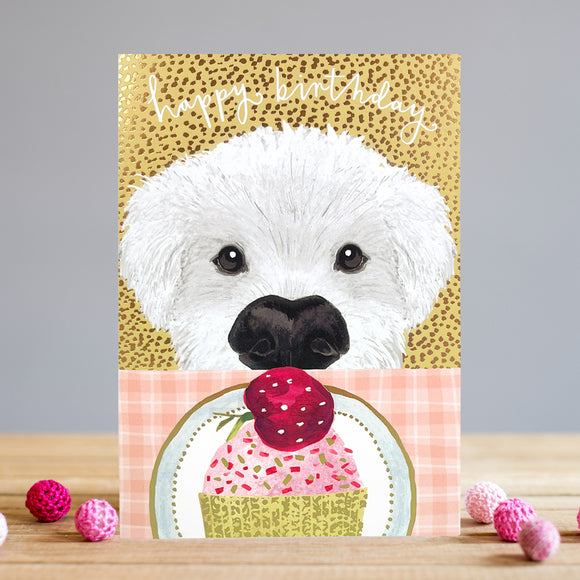 This fun and bright Louise Tiler birthday card features a white pup peering over the edge of a table at a beautiful cupcake - topped with pink icing, sprinkles and a cherry! White text on the front of the card reads 