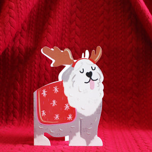 This adorable and unusual christmas card is cut into the shape of a shaggy old english sheepdog wearing a christmas jumper and reindeer antler headband.