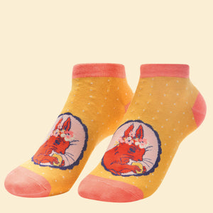 This pair of ladies trainer socks from fashion brand Powder are decorated with a cameo design showing a cute red squirrel, wearing a flower crown, nibbling on a nut. The socks have a striking orange contrast at the toe and heel.