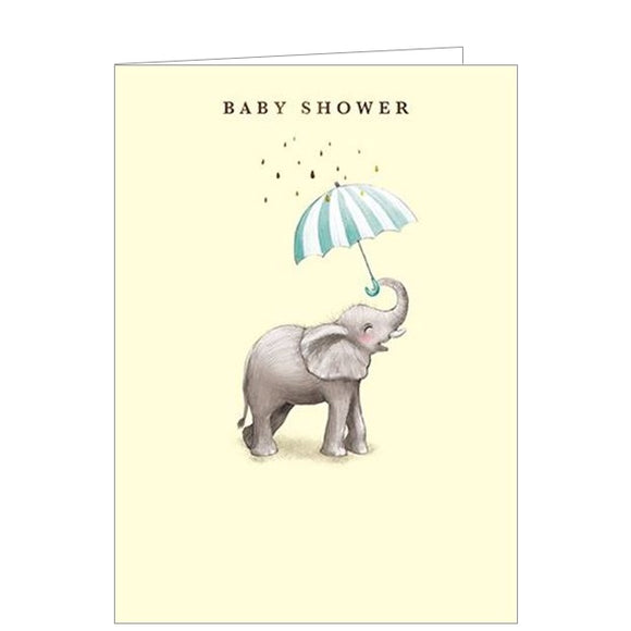 Sweet and simple, this pale yellow baby shower greetings card is decorated with an illustration of a baby elephant holding a blue and white umbrella in his trunk. Gold text on the front of the card reads 