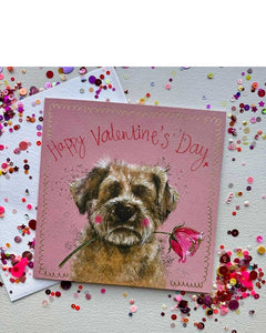 This lovely Valentine's card features Alex Clark's illustration of a terrier type dog, holding a rose blossom in his mouth. The background is a lovely pink shade with gold details and text reads "Happy Valentine's Day".