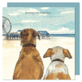 A cute card showing two dogs sat at the beach front