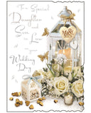 Celebrate your daughter’s special day with this beautifully designed wedding card for a daughter and son-in-law by Jonny Javelin. Featuring a delicate illustration of a romantic lantern surrounded by soft white roses, a wedding favour box, and heart-shaped confetti, it captures the elegance and joy of a wedding celebration. The front of the card is finished with shimmering&nbsp;silver foil text that reads "To a Special Daughter and Son-in-Law on Your Wedding Day."