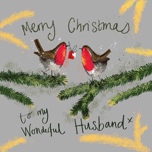 Part of Alex Clark's Christmas card collection, this Christmas card is decorated with Alex's painting of two red-breasted robins perched on branches of a christmas tree - one robin is holding a christmas gift in its beak. Black text on the front of the card reads "Merry Christmas to my wonderful Husband x".