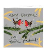 Part of Alex Clark's Christmas card collection, this Christmas card is decorated with Alex's painting of two robins perched on branches. One robin is holding a christmas gift in its beak. The text on the front of the card reads "Merry Christmas to my wonderful Husband x".