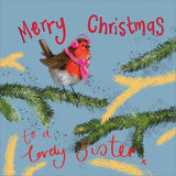 Part of Alex Clark's Christmas card collection, this Christmas card for a special sister is decorated with Alex's painting of a robin, wearing a pink knitted scarf and bobble hat perched on a fir-tree branch. The text on the front of the card reads "Merry Christmas to a lovely Sister x".