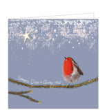 Part of Alex Clark's Christmas card collection, this Christmas card is decorated with Alex's painting a robin, perched on a fir tree branch, looking up at a star in the sky. The text on the front of the card reads "Someone Dear is Always Near x".