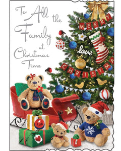 This christmas card for a special family is decorated with&nbsp;an illustration of three teddy bears sitting next to a beautifully adorned Christmas tree. Silver text on the front of this Jonny Javelin Christmas card reads "To All the Family at Christmas Time".