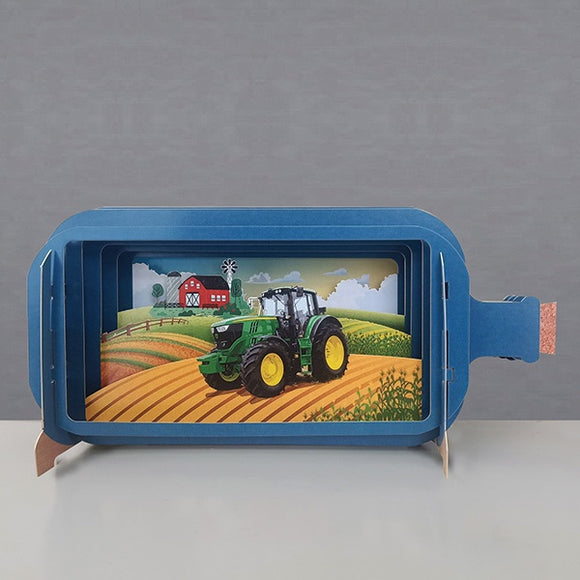 .This fabulous pop-up greetings card is made of multiple layers of laser cut card to create a wonderful 3d image of a green tractor at work in a country field. There is a red barn in the background.