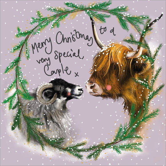 Part of Alex Clark's Christmas card collection, this Christmas card for a special couple is decorated with Alex's painting of a highland cow nose to nose with a ram, set within a festive wreath. The text on the front of the card reads 