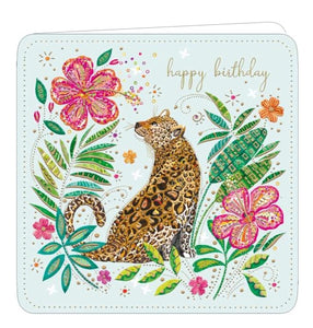 This lovely birthday card is decorated with an image of a leopard, with colourful spots, surrounded by rich pink and gold flowers. The text on the front of the card reads "happy birthday".