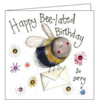 Part of Alex Clark's Sparkle card collection, finished with a dusting of glitter. This belated birthday card features a smiling bee carrying a birthday card. Text on the front of the card reads "Happy Bee-lated Birthday...so sorry x".
