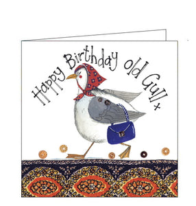 Part of Alex Clark's "Little Seaside Sparkle" mini greetings card collection, finished with a dusting of glitter. This birthday card is decorated with a seagull in a headscarf carrying a handbag. Text on the front of the card reads "Happy Birthday old gull x"
