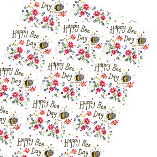 This Alex Clark wrapping paper features a repeating design of a smiling bumble bee carrying a flower, surrounded by brightly coloured flowers and text that reads 