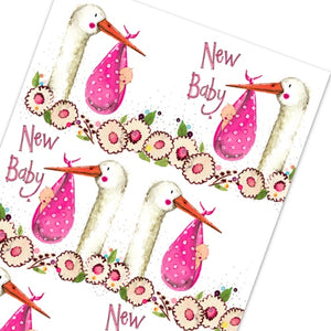 This Alex Clark wrapping paper features a repeating design of a stork carrying a baby in a pink bundle. Text on the wrap reads "New Baby x"