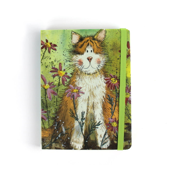 Official Alex Clark illustrated stationery range of an A6 notebook with toffee the cat on the cover, lined pages inside and polka dots on the back. Notebook is secured with an elastic band. Toffee the cat is a ginger tabby cat and he sits among purple flowers