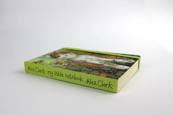 Official Alex Clark illustrated stationery range of an A6 notebook with toffee the cat on the cover, lined pages inside and polka dots on the back. Notebook is secured with an elastic band. “Alex Clark my little notebook” is written on the spine