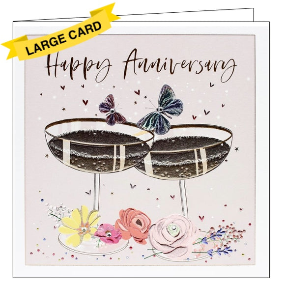 This beautiful, luxury anniversary card is decorated with two metallic champagne coupes surrounded by flowers and butterflies embellished with silver jewels. Gold text on the front of the card reads 