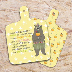 This small chopping board from Dandelion Stationery is decorated with bear - dressed in a flower crown and grass skirt, holding a cocktail. The text on the front of the choppingboard reads "drinking 8 glasses of water in 24 hours seems almost impossible...but 5 cocktails, 2 gins and 3 shots in 2 hours goes down like a penguin on a water slide...". The reverse side of the board is decorated with a repeating pattern of cocktails.