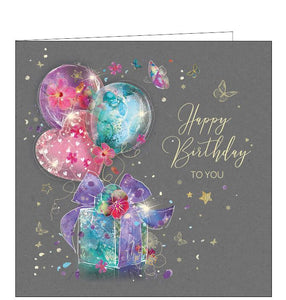 This birthday card is decorated with pink, purple and blue balloons tied to a coordinating birthday gift. Metallic gold text on the front of the card reads "Happy Birthday to you".